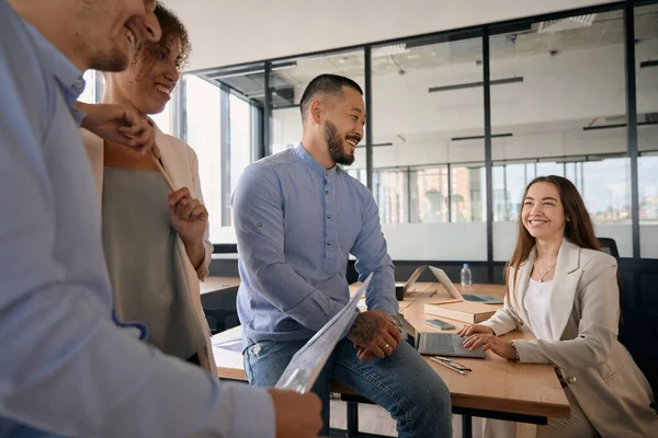 Cropped photo of men and women talking with colleagues while in modern coworking space