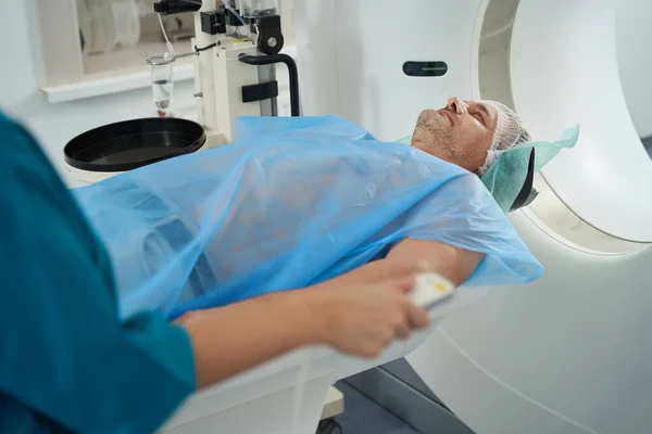 Patient in a diagnostic center in special clothes goes to the camera of a modern tomograph