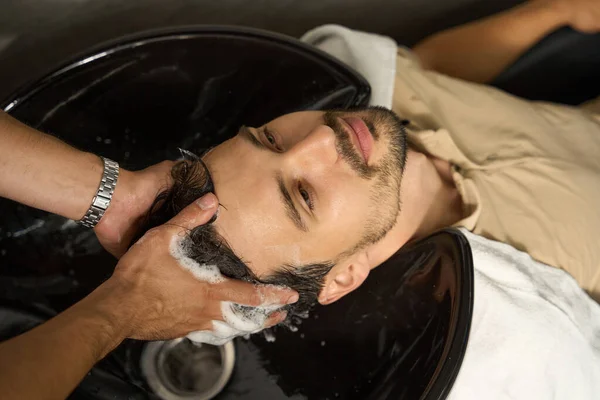 Przystojny Facet Głową Zlewie Fryzjera Którego Włosy Umył Profesjonalny Specjalista — Zdjęcie stockowe