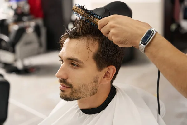 Привлекательный Парень Сидящий Парикмахерской Высушенными Волосами Стилизованный Профессиональным Парикмахером — стоковое фото