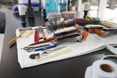 Kuaförde temiz beyaz bir havluya yerleştirilmiş çeşitli berber aletlerinin fotoğrafları yok.