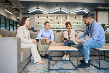 Ciddi odaklı iş adamı, iş ortaklarının huzurunda belgeye bakıyor.