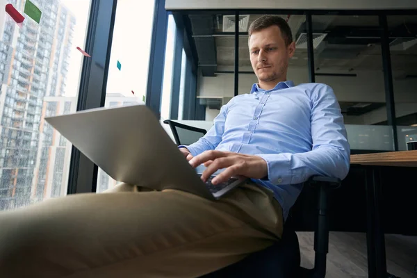집약적 사무직 근로자가 휴대용 컴퓨터로 타자를 하면서 의자에 — 스톡 사진