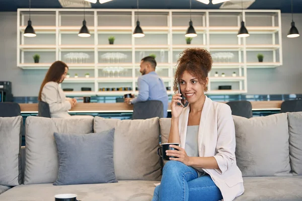 Joyful Jonge Vrouw Praten Haar Smartphone Terwijl Zitten Bank Working — Stockfoto