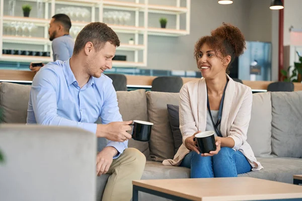 Junger Mann Und Fröhliche Frau Sitzen Auf Sofa Und Unterhalten — Stockfoto