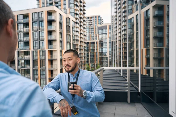 Young Company Employee Talking His Coworker While Leaning Balcony Guardrail — Stock Photo, Image