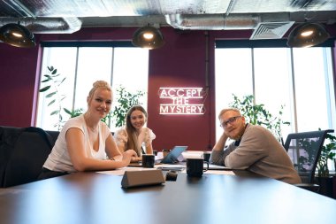Bayan mimarlar ve erkek meslektaşları toplantı masasında oturup ileriye bakıyorlar.