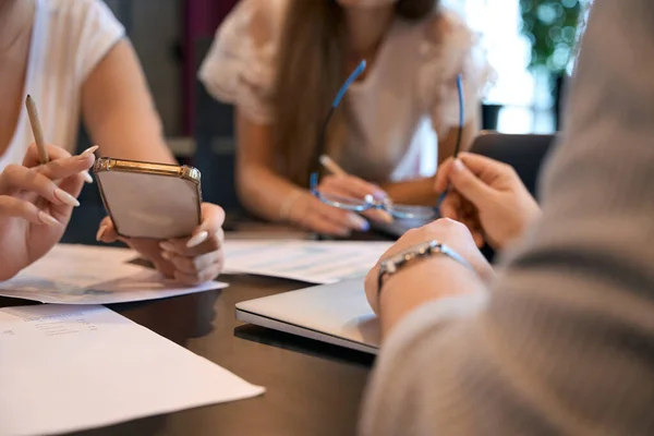 Cropped photo of company manager with smartphone in hand communicating with colleagues