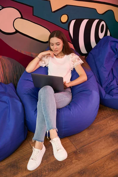 Freelancer Feminino Concentrado Sentado Cadeira Saco Feijão Trabalhando Laptop Espaço — Fotografia de Stock