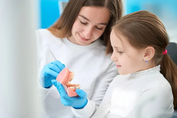 Усміхнений Стоматолог Сидить Поруч Дев Ятнадцятьма Дітьми Вказує Зуб Стоматологічну — стокове фото