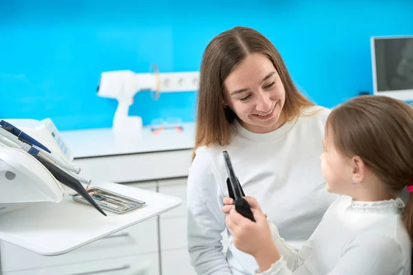 Pedodontista Sorrindo Para Pouco Paciente Sentado Lado Dela Com Espelho — Fotografia de Stock