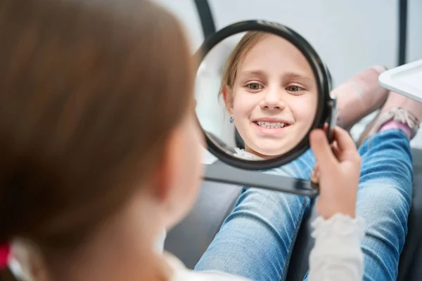 Pequeña Paciente Concentrada Sentada Silla Dental Mirando Boca Abierta Espejo —  Fotos de Stock