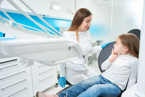 Empathischer Kinderzahnarzt Betrachtet Frühchen Das Während Der Sprechstunde Über Zahnschmerzen — Stockfoto