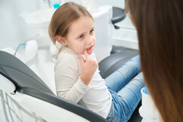 坐在牙椅上的儿童在牙科医生面前露出有问题的牙齿 — 图库照片