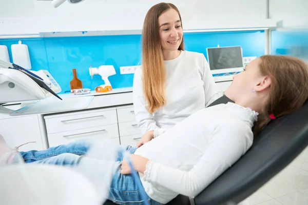 Lachende Vriendelijke Pedodontist Gesprek Met Kind Liggend Tandartsstoel Tijdens Primair — Stockfoto