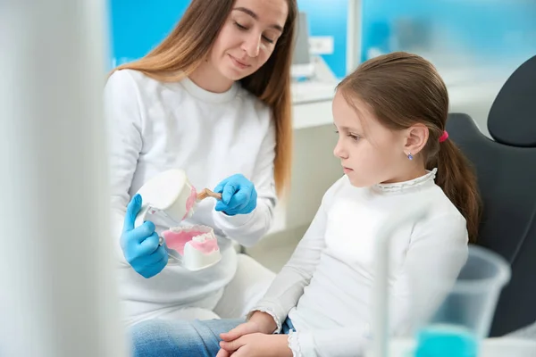 Стоматолог Чистить Зуби Моделі Зубною Щіткою Перед Серйозною Заздалегідью Дівчиною — стокове фото