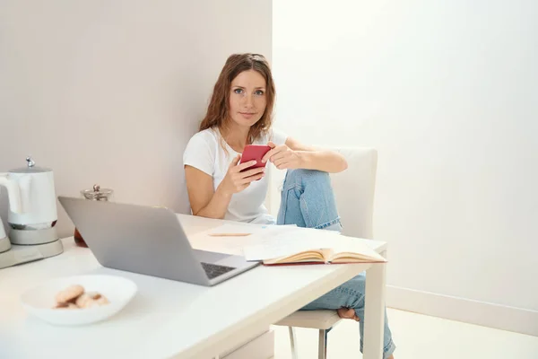 Signora Calma Guarda Attraverso Telefono Mentre Computer Portatile Aperto Una — Foto Stock