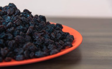 Kurutulmuş siyah kuru üzüm. Kuru üzümler kuruyan taze üzümlerle elde edilir. Kurutulmuş meyve grubuna dahil edilerek, eşlik edilmeden pişirilen veya yenilen en popüler gıdalardan biri haline getirilirler..