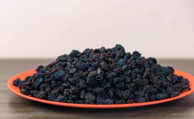 Kurutulmuş siyah kuru üzüm. Kuru üzümler kuruyan taze üzümlerle elde edilir. Kurutulmuş meyve grubuna dahil edilerek, eşlik edilmeden pişirilen veya yenilen en popüler gıdalardan biri haline getirilirler..