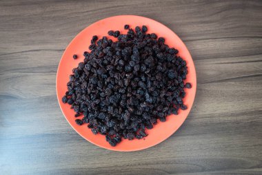 Kurutulmuş siyah kuru üzüm. Kuru üzümler kuruyan taze üzümlerle elde edilir. Kurutulmuş meyve grubuna dahil edilerek, eşlik edilmeden pişirilen veya yenilen en popüler gıdalardan biri haline getirilirler..