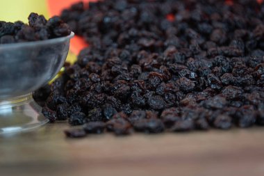 Kurutulmuş siyah kuru üzüm. Kuru üzümler kuruyan taze üzümlerle elde edilir. Kurutulmuş meyve grubuna dahil edilerek, eşlik edilmeden pişirilen veya yenilen en popüler gıdalardan biri haline getirilirler..