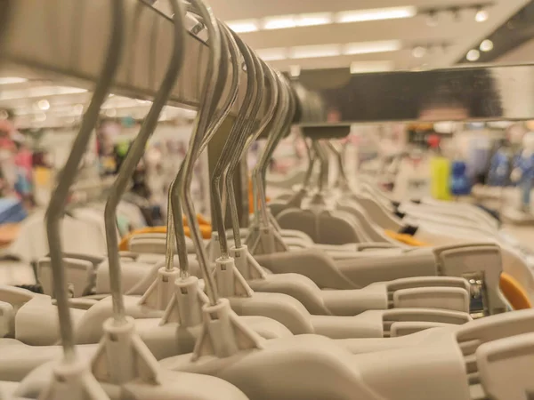 Coat racks in a department store. Clothing sale store material. Utensils for displaying fashion pieces. Large department store environment.