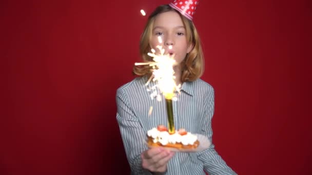 Young teen girl in birthday cap holding cake with candle — Stock Video