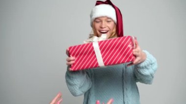 Noel Baba şapkalı mutlu genç kız hediyesini tutuyor.