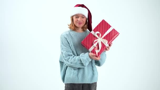 สาวน้อยมีความสุขในหมวกซานตาคลอสถือของขวัญ — วีดีโอสต็อก