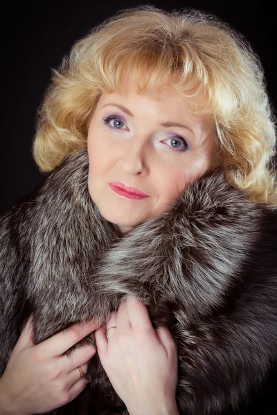 Middle-aged woman posing in fur vest — Stock Photo, Image