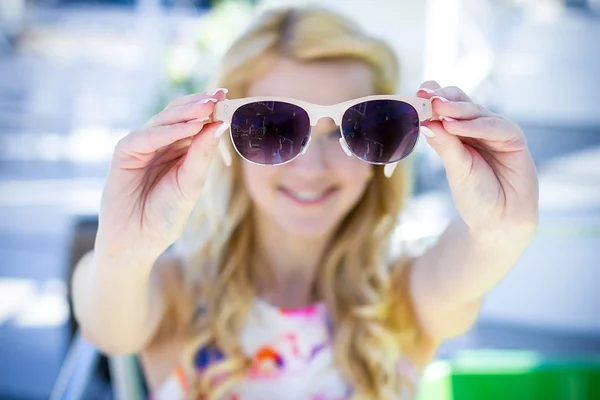 Menina mostrando óculos de sol para a câmera — Fotografia de Stock