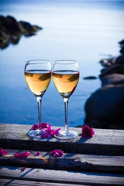 Copas de vino blanco con pétalos — Foto de Stock