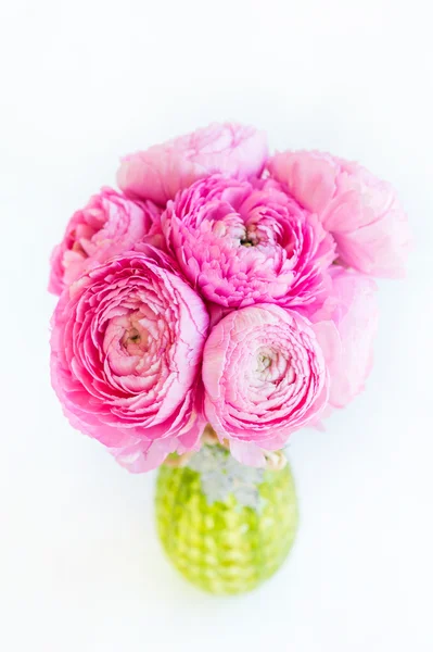 Hermosas renónculas de color rosa brillante en un jarrón verde — Foto de Stock