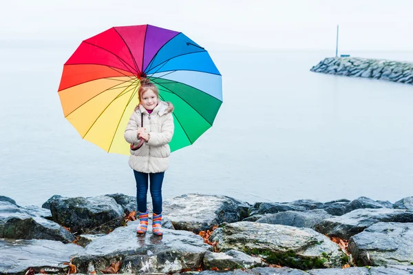 Cute little girl under rain with colorful umbrella — Stock Photo, Image