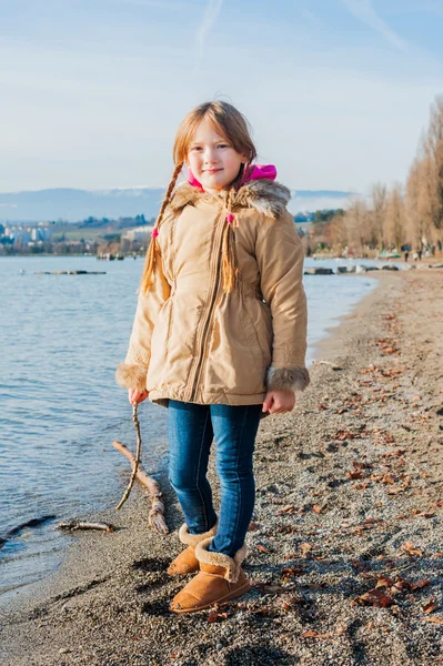 Little girl playing next to lake in a cold time — Stock Photo, Image