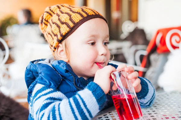 Bonito menino bebê bebendo xarope em um café — Fotografia de Stock