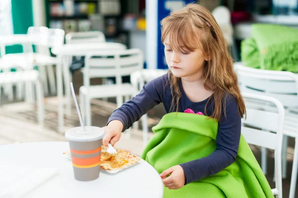 Красивая маленькая девочка ест блины и пьет горячий шоколад в кафе — стоковое фото