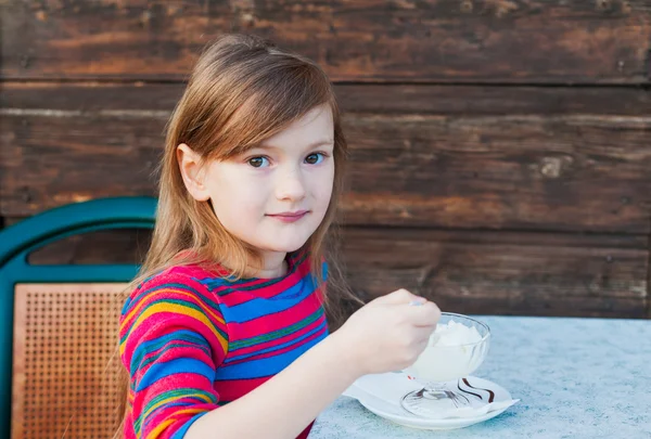 Hermosa niña comiendo helado en una terraza en un buen día — Foto de Stock
