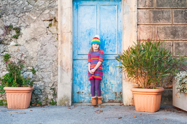 Schöne kleine Mädchen in einem bunten Kleid und Hut posiert — Stockfoto