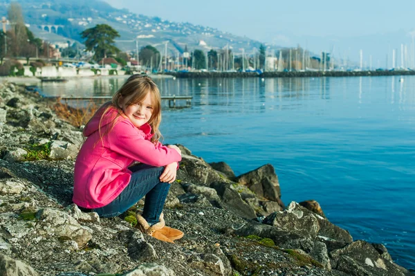 Utomhus porträtt av en vacker liten flicka på en fin solig dag vid sjön — Stockfoto