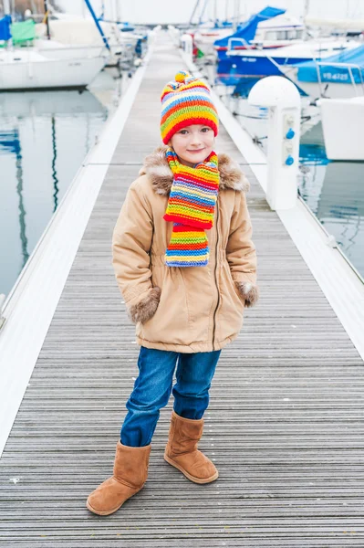 Portrait of a cute little girl in a colorful hat and scarf — Stock Photo, Image