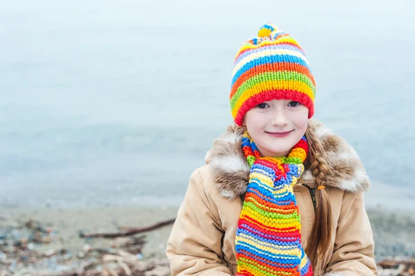 Renkli şapka ve atkı, sevimli küçük bir kız portresi — Stok fotoğraf