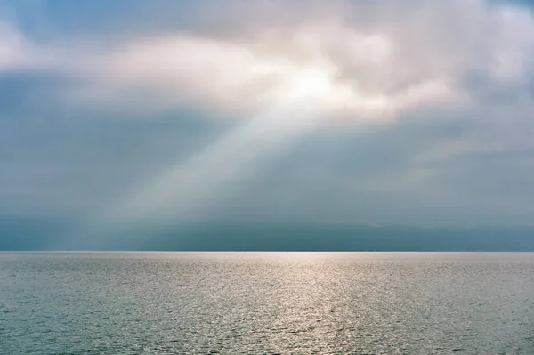 Stralen Van Licht Vallen Door Wolken Kalm Wateroppervlak — Stockfoto