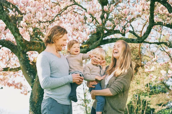 Venkovní Portrét Šťastné Mladé Rodiny Hrající Jarním Parku Pod Kvetoucím — Stock fotografie