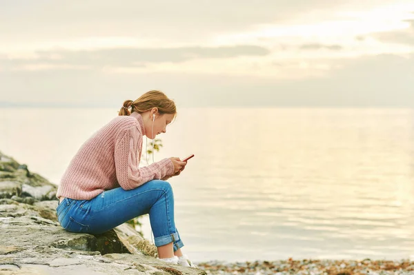 stock image Outdoor portrait of young teenage girl listening music next to lake or sea, image taken in Lausanne, Switzerland