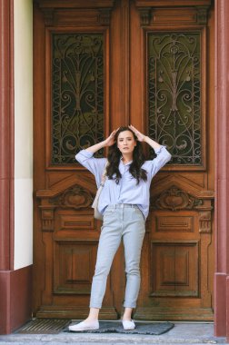 Mavi gömlekli, dışarıda poz veren güzel bir genç kadının moda portresi.