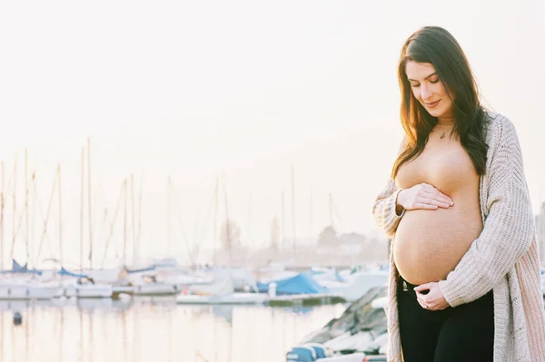 美丽孕妇的户外肖像摸着肚子 清早走在湖边 — 图库照片