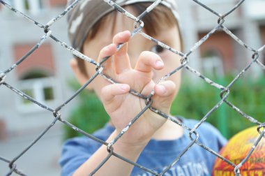 Oğlan demir parmaklıklar ardında el