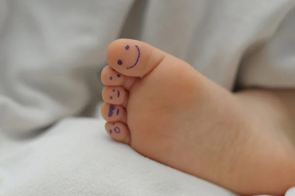 Children  foot with smiles on fingers — Stock Photo, Image