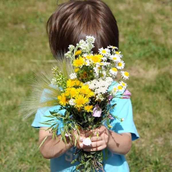 Boy behind the bouquet of flowers — Stock Photo, Image
